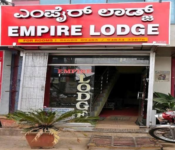 a store entrance with a red and white sign at Empire lodge in Chikmagalūr