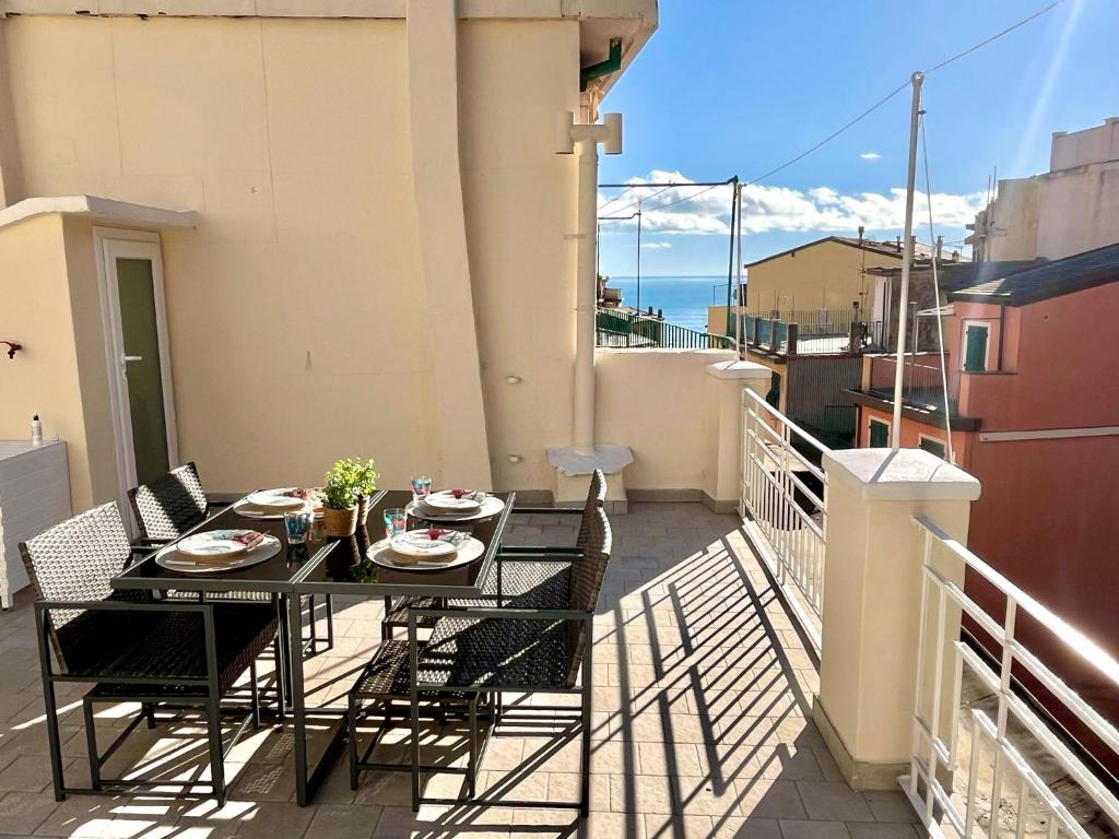 a table and chairs on a balcony with a view of the ocean at Terrazza Meraviglia in Riomaggiore