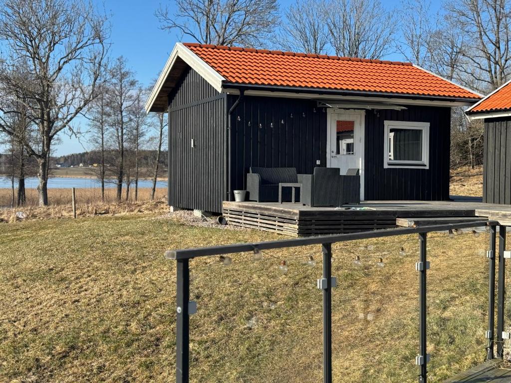 a black house with an orange roof at Atterfallshus1 in Nyköping