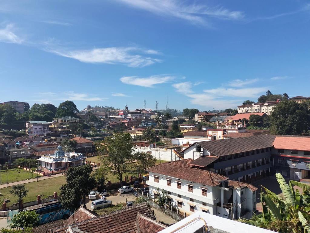 uitzicht op een stad met gebouwen en bomen bij Coorg Orange Villa in Madikeri