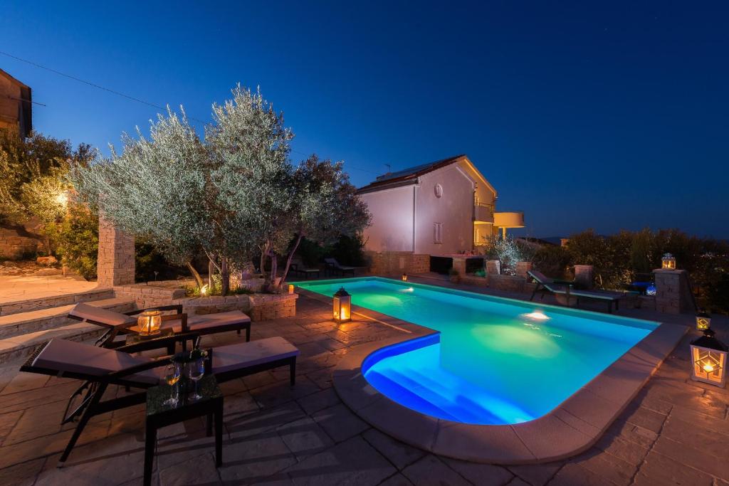 a swimming pool in a backyard at night at Family-friendly apartments with swimming pool Murter - 16655 in Murter