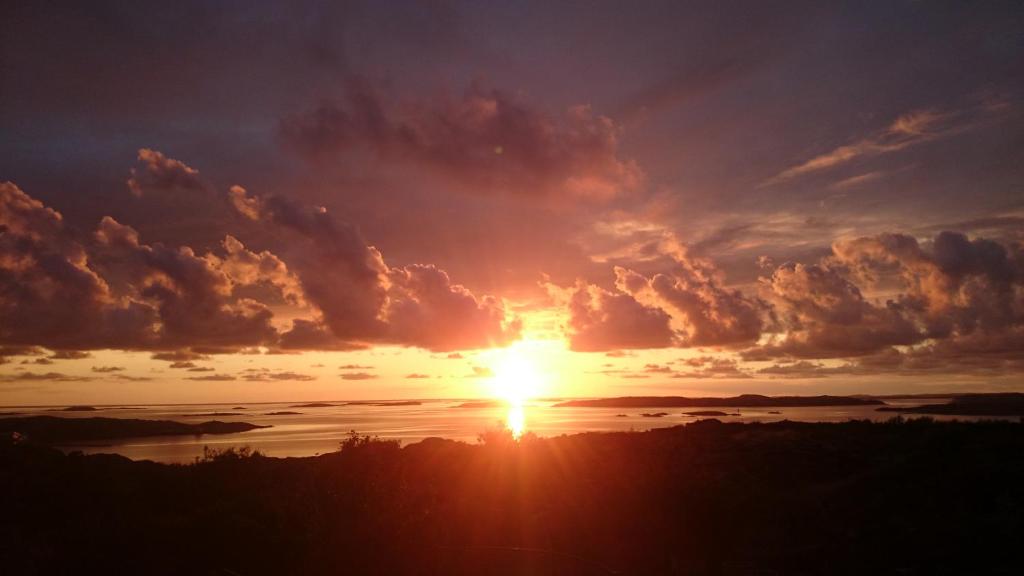 um pôr do sol sobre um corpo de água com nuvens em Lysekil sunset Villa em Lysekil