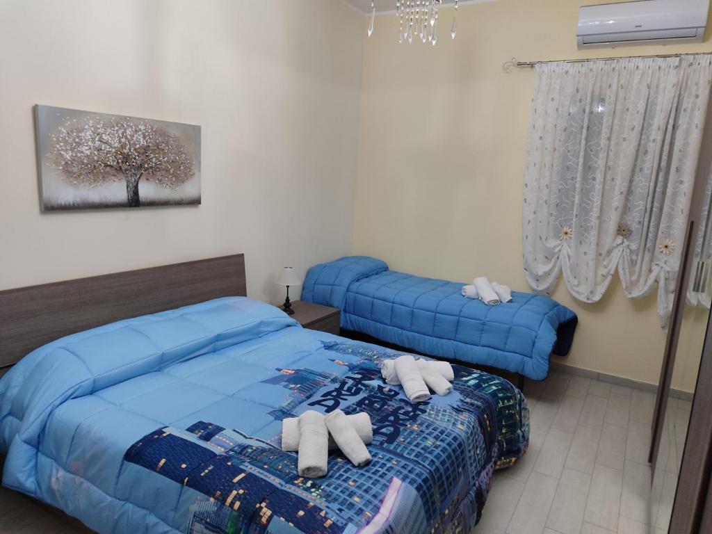 - une chambre avec 2 lits et une couette bleue dans l'établissement LA MAISON DU PORT, à Licata