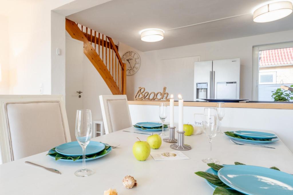 a dining room with a white table with blue plates at Strand und Ferienhaus ,,INGER'' mit Terrasse in Rappin