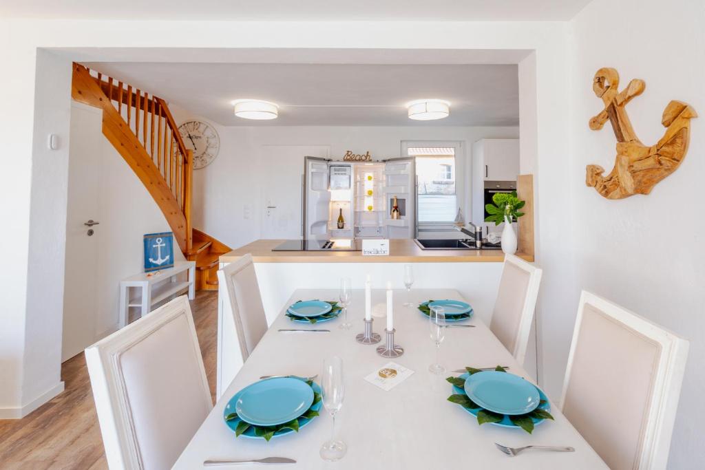 a kitchen and dining room with a white table and chairs at ,,Haus INGER'' idyllische Doppelhaushälfte am Banzelvitzer Strand in Rappin