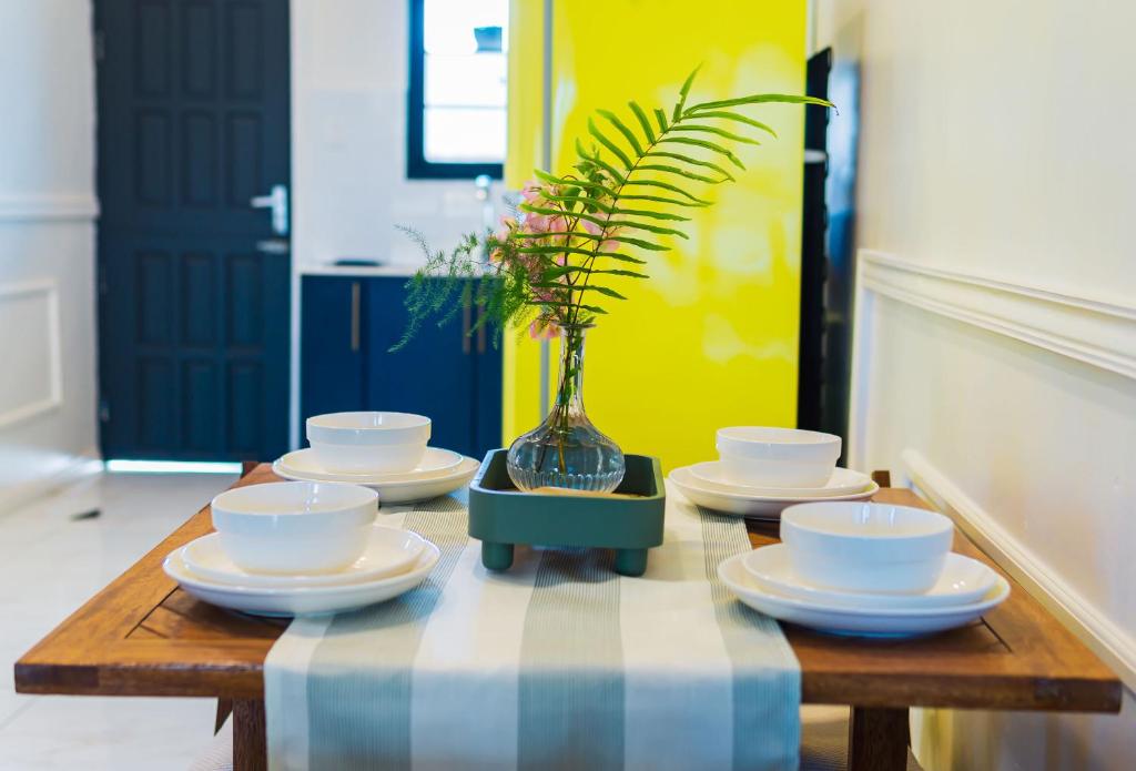 una mesa con platos y una maceta en ella en Cozy and quirky Wolf Apartment, en Paramaribo