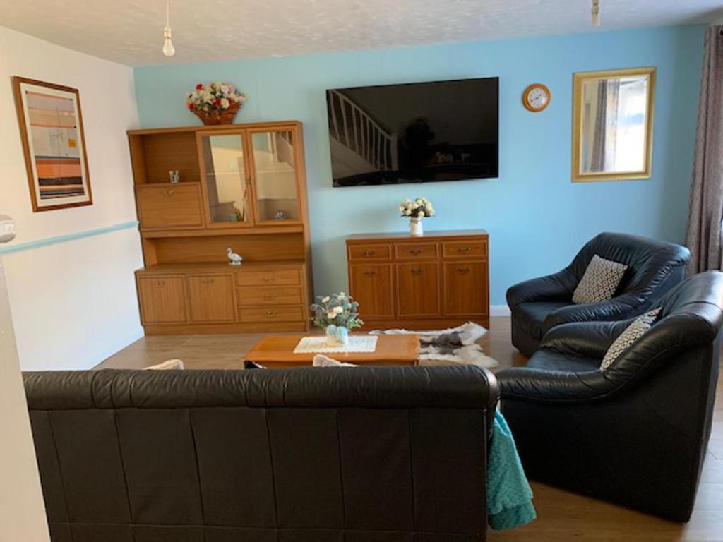 a living room with a couch and two chairs and a tv at Beautiful 4-Bed House in Erith in Erith
