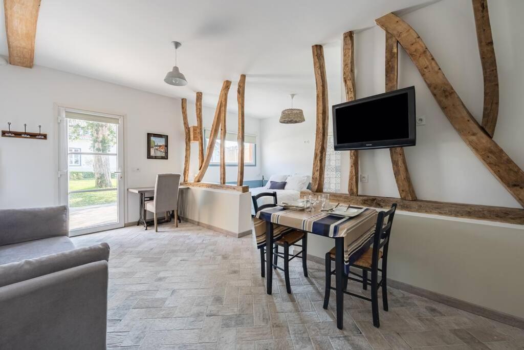a living room with a dining table and a tv at Plain pied avec terrasse à 5 minutes de Berck in Verton