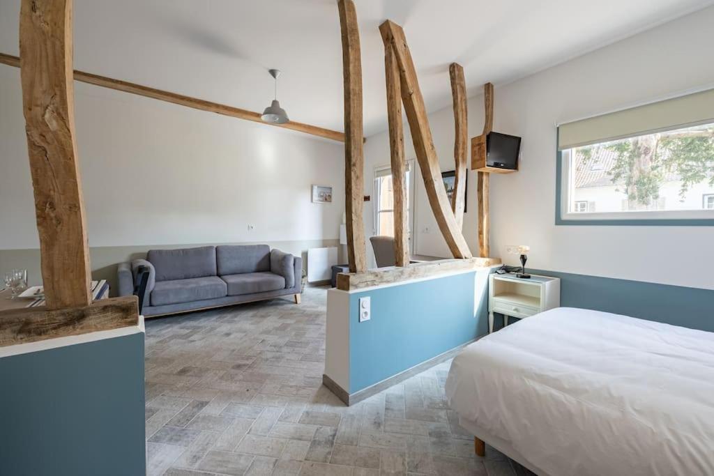 a bedroom with a bed and a couch at Plain pied avec terrasse à 5 minutes de Berck in Verton