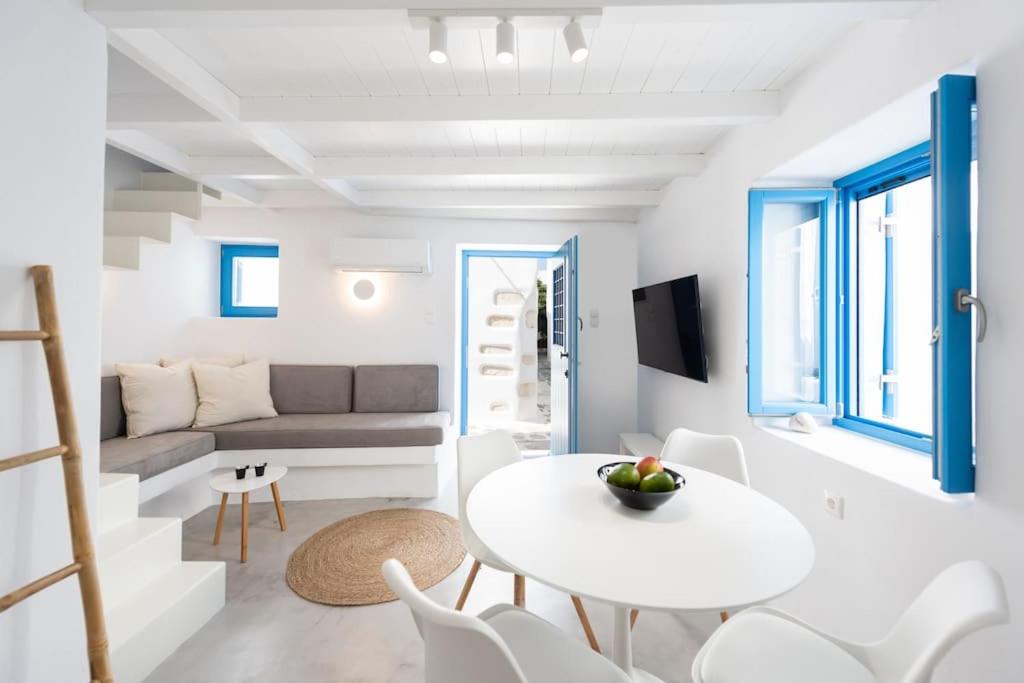 a white living room with a table and a couch at Blue Paros House Paroikia Center close to port in Kampos Paros
