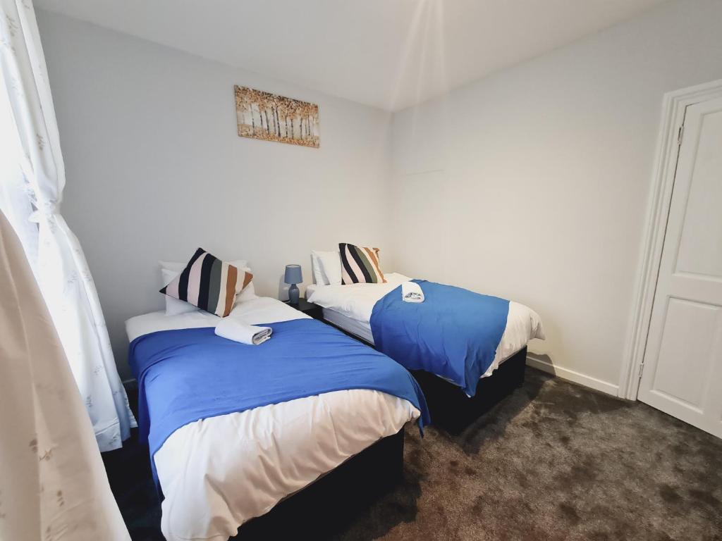 - 2 lits dans un dortoir bleu et blanc dans l'établissement Belvedere House 2 bedroom Greater London, à Belvedere
