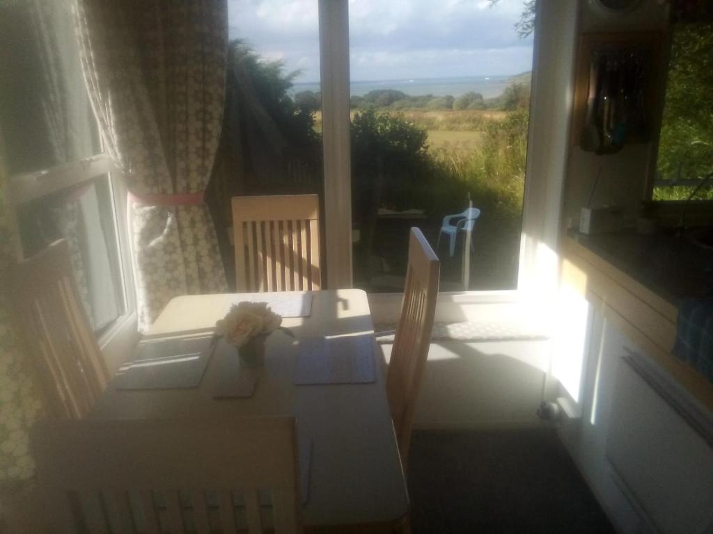 a table and chairs in front of a window at 11 Oaklands in Porchfield