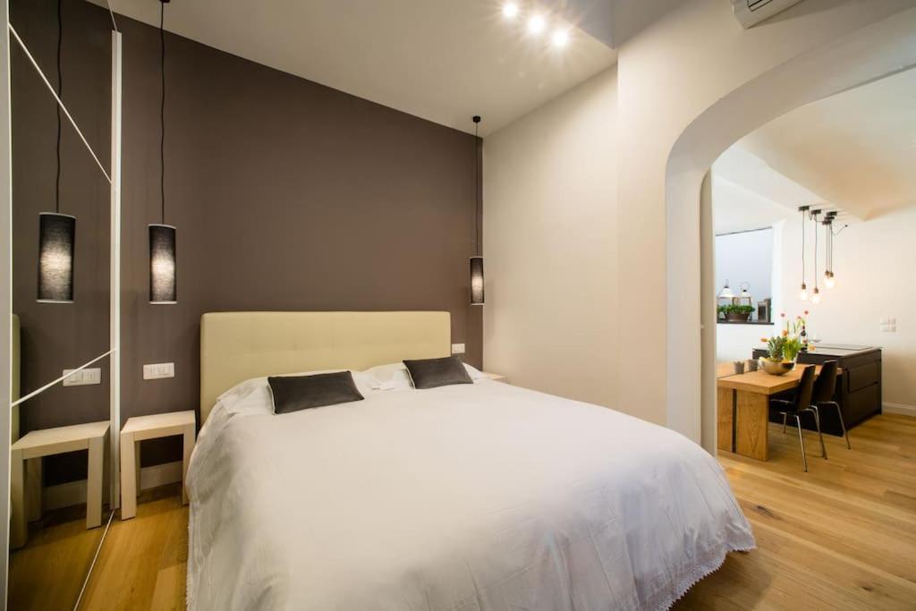 a bedroom with a large white bed and a desk at Tornabuoni TOT - luxury apartments in Florence