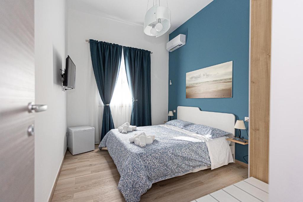 una camera da letto con un letto e una parete blu di La Rosa di Sharon a Portopalo