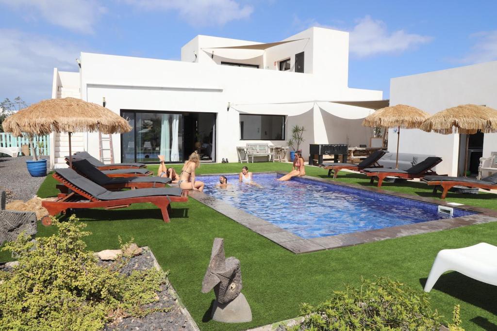 a group of people in a swimming pool in a house at Villa Koa - Riders Surf n Bike in El Roque
