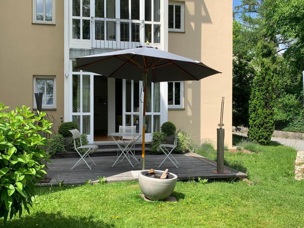 a patio with an umbrella in front of a house at Ferienwohnung auf ehemaligem Mühlengrund in Neuhaus am Inn