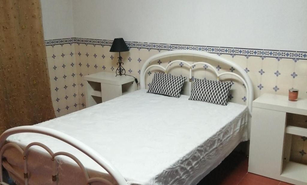 een slaapkamer met een wit bed met 2 kussens bij Good Sleep in Santarém
