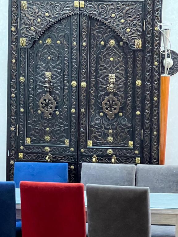 a black door with four colorful chairs in front of it at Casablanca heart of town apartment in Casablanca
