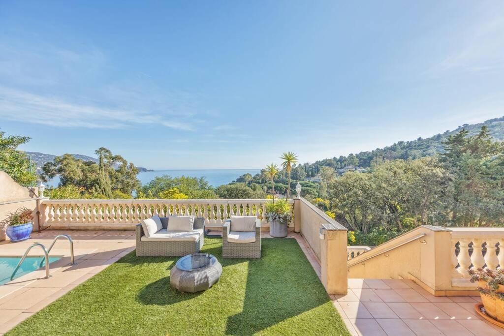 un patio con muebles de exterior y una piscina en Villa Piscine, vue mer Cap Nègre, en Le Lavandou