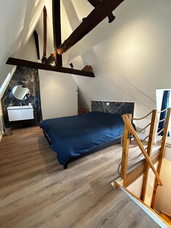 a bedroom with a blue bed in a attic at La Joaillerie in Bourges