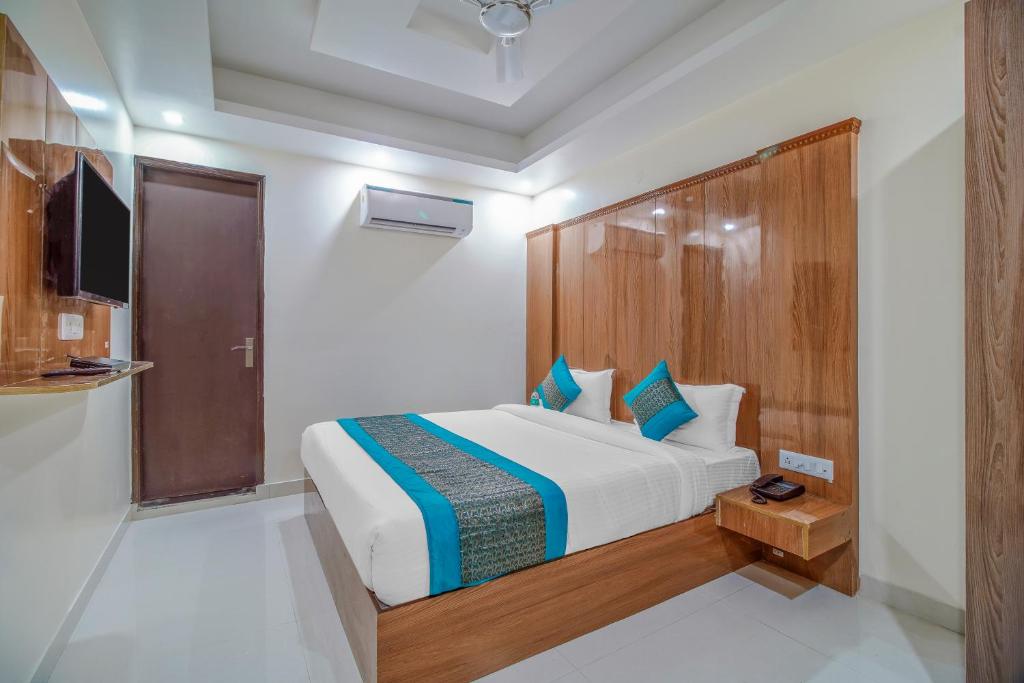 sypialnia z dużym łóżkiem z drewnianym zagłówkiem w obiekcie hotel the paradise inn w Nowym Delhi