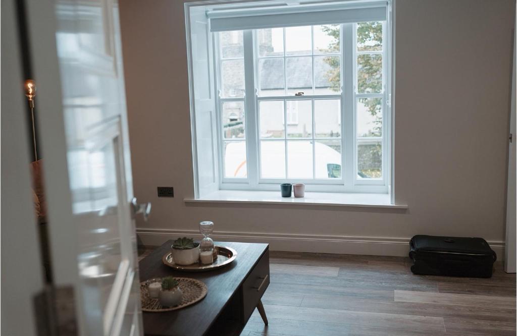 ein Wohnzimmer mit einem Tisch und einem großen Fenster in der Unterkunft Apartment at 68 in Saintfield