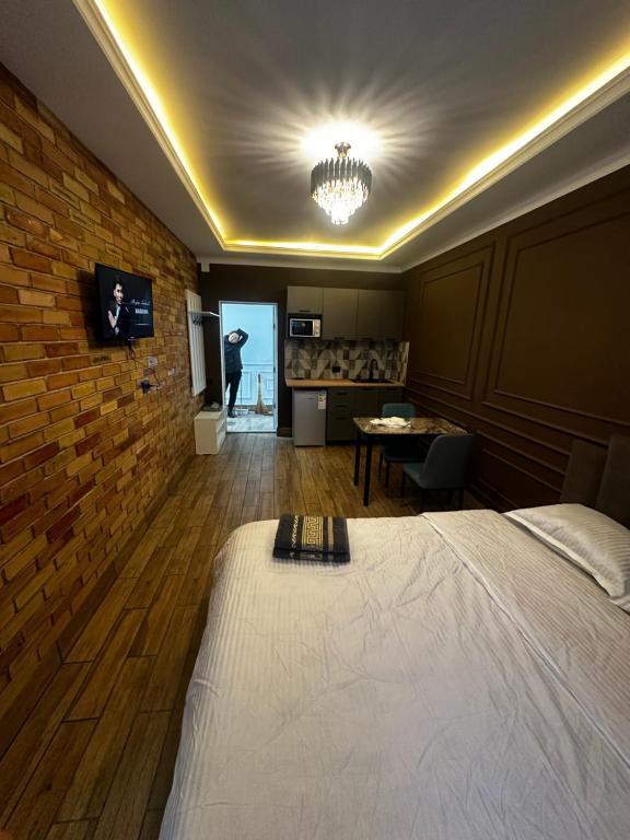 a bedroom with a bed and a brick wall at Байтеке in Bishkek