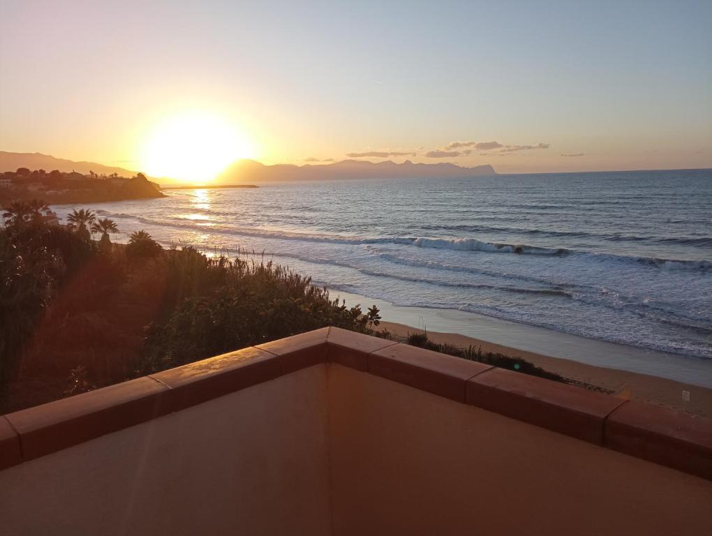 d'un balcon offrant une vue sur l'océan au coucher du soleil. dans l'établissement LA FINESTRA SUL MARE, à Trappeto