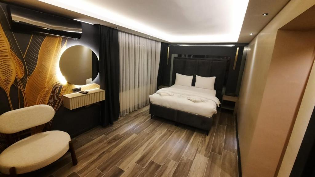 ein kleines Zimmer mit einem Bett und einem Spiegel in der Unterkunft TALLES CITY HOTEL in Konak
