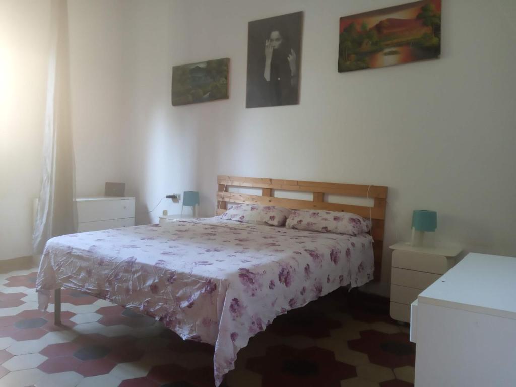 een slaapkamer met een bed met een roze sprei bij Bologna Maison Primaticcio in Bologna