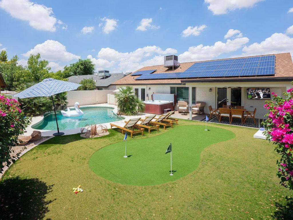 a backyard with a putting green and a pool at Scottsdale - 6839 E Kelton Lane in Scottsdale