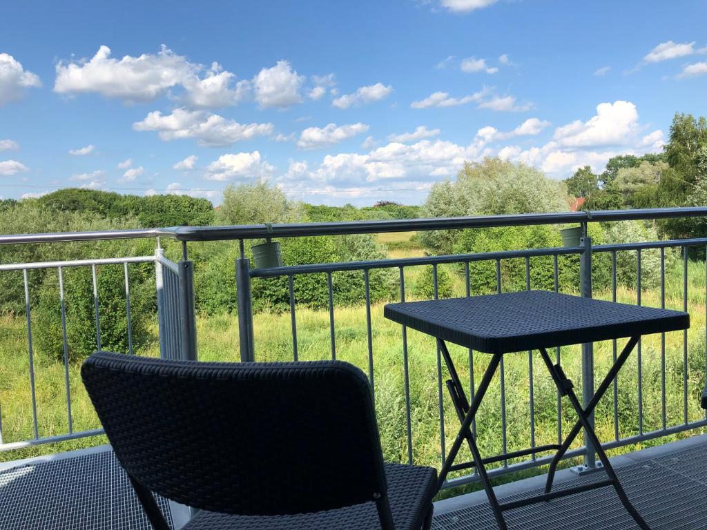 a table and chair on a balcony with a view of a field at Auszeit im Grünen 