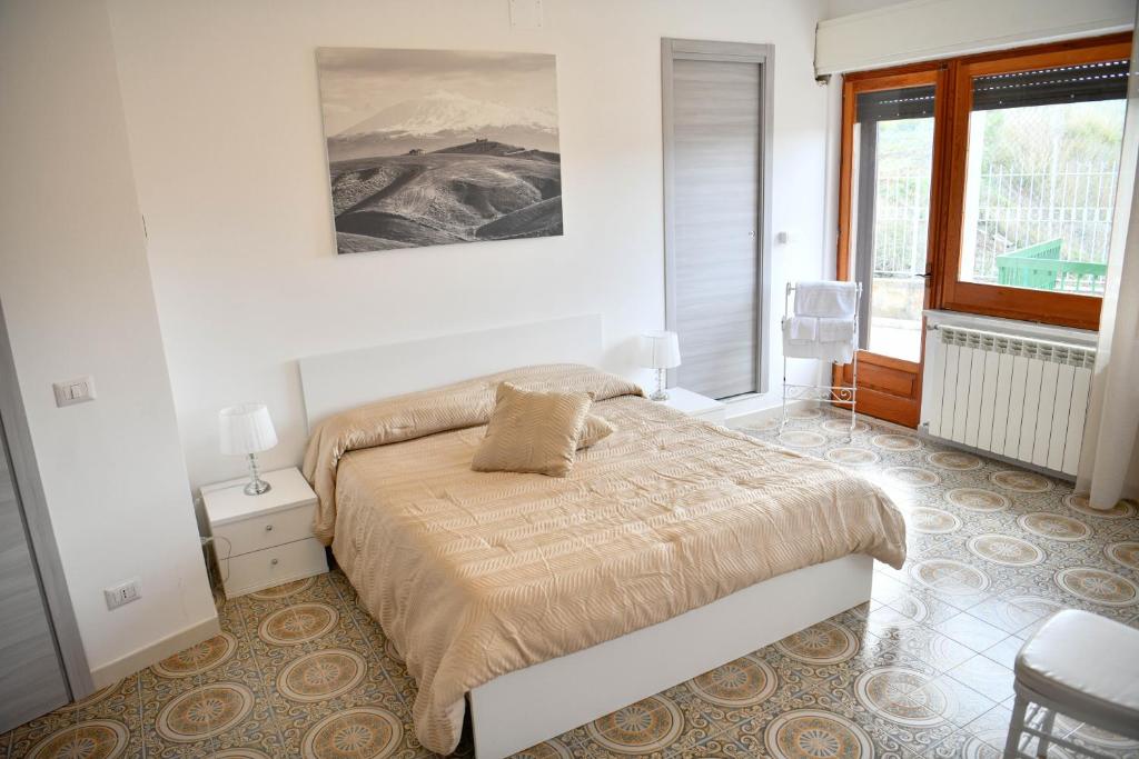 Habitación blanca con cama y ventana en B&B Francesca, en Enna