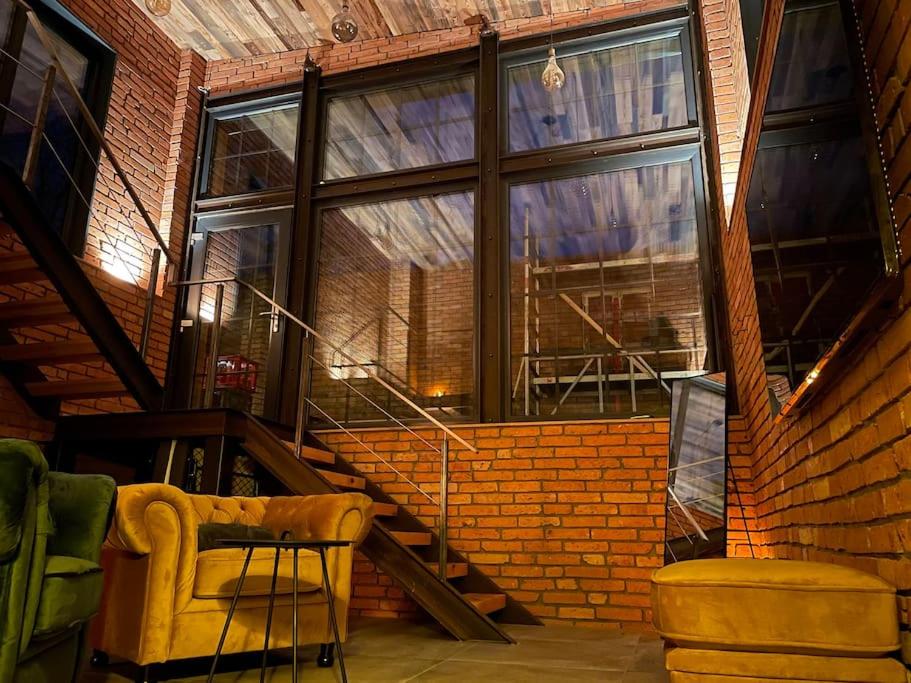 a room with a staircase and a brick wall at Ferienwohnung Loft Schwielowsee mit Sauna in Schwielowsee