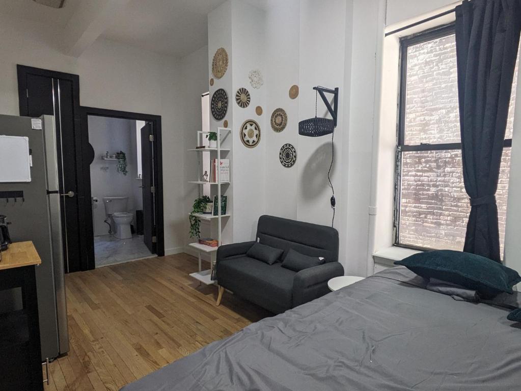 a bedroom with a bed and a chair and a window at Studio in Union Square in New York