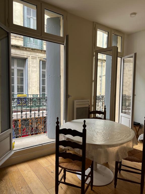une salle à manger avec une table et une grande fenêtre dans l'établissement Centre historique rue Saint Guilhem, à Montpellier