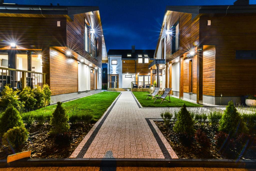 a walkway between two buildings at night at Liliowa 12 in Dębki