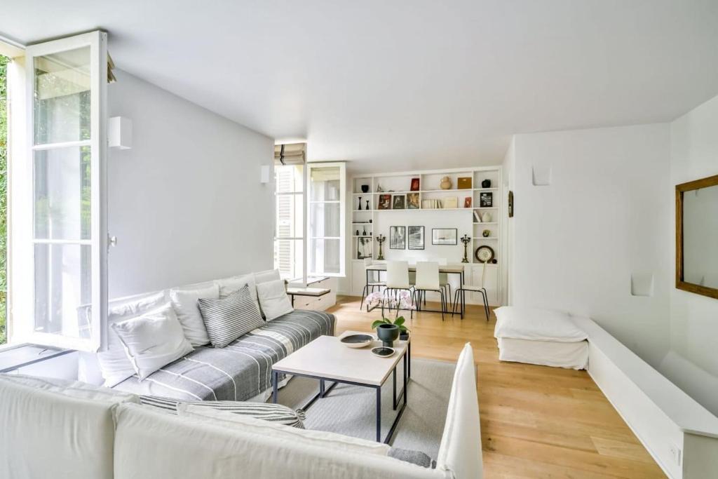 a white living room with a couch and a table at Superb apartment in the heart of Saint-Germain in Paris