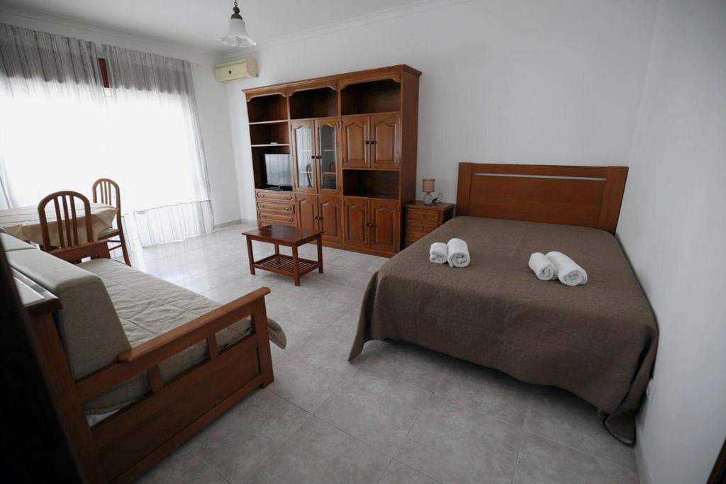 1 dormitorio con 2 camas y toallas blancas. en STUDIO COMPLETO PARA 2 PESSOAS, en Albufeira