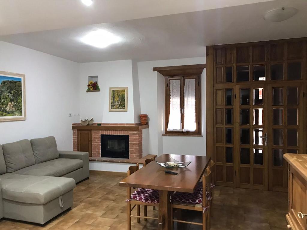 un soggiorno con un divano e un tavolo di Casa La Quercia a Chiusi della Verna