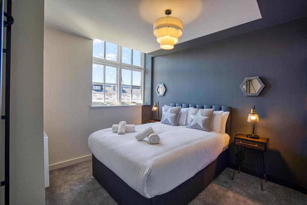 a bedroom with a large white bed with a window at Renaissance House - 16 Picturesque Apartments in Southport in Southport