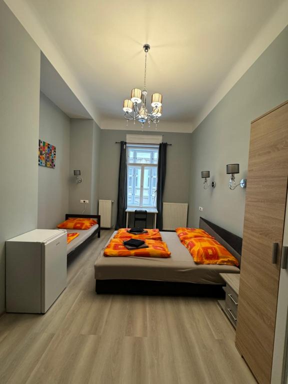 a bedroom with two beds and a chandelier at Boomerang Hostel in Budapest
