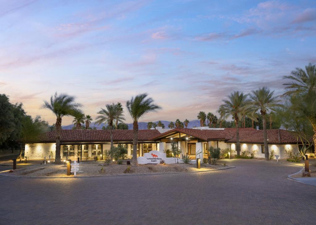 un complexe avec des palmiers en face d'un bâtiment dans l'établissement La Casa Del Zorro Resort & Spa, à Borrego Springs