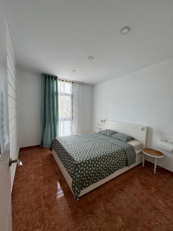 una camera da letto con un letto e una grande finestra di las Piteras ad Arona