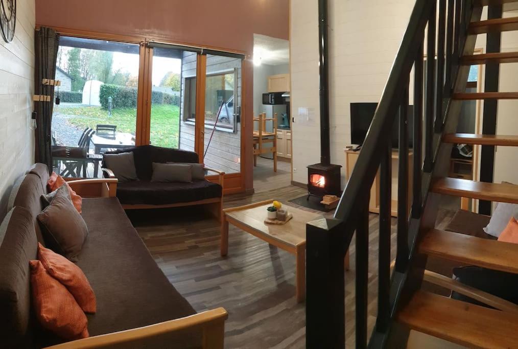 a living room with a couch and a fireplace at Gîte n° 20, en pleine nature, frontalier in Signy-le-Petit