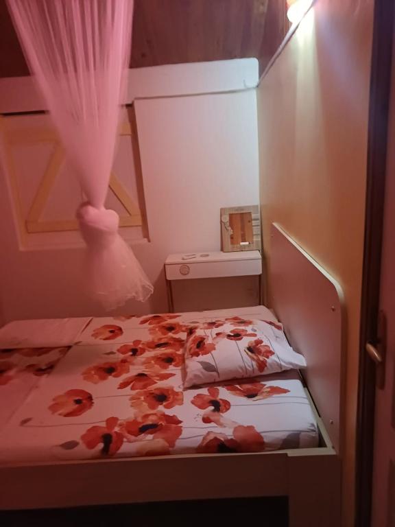 ein kleines Schlafzimmer mit einem Bett mit Blumen darauf in der Unterkunft La petite perle in Ducos