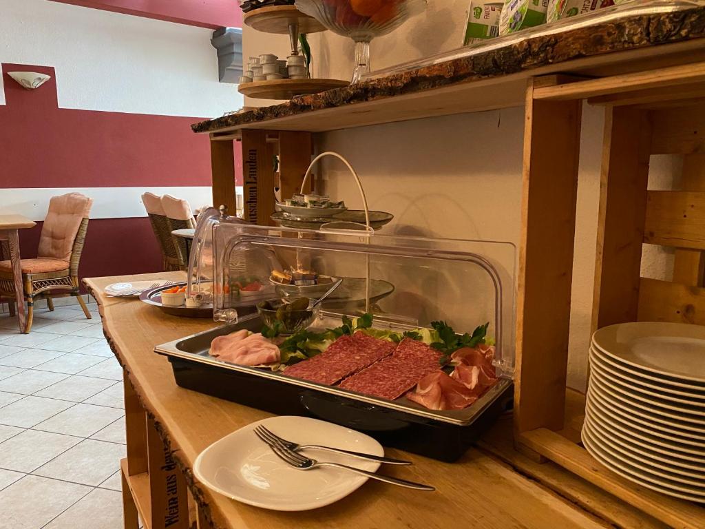 a buffet with meat and other food on a table at Hotel Weinstube am Markt in Gerolzhofen