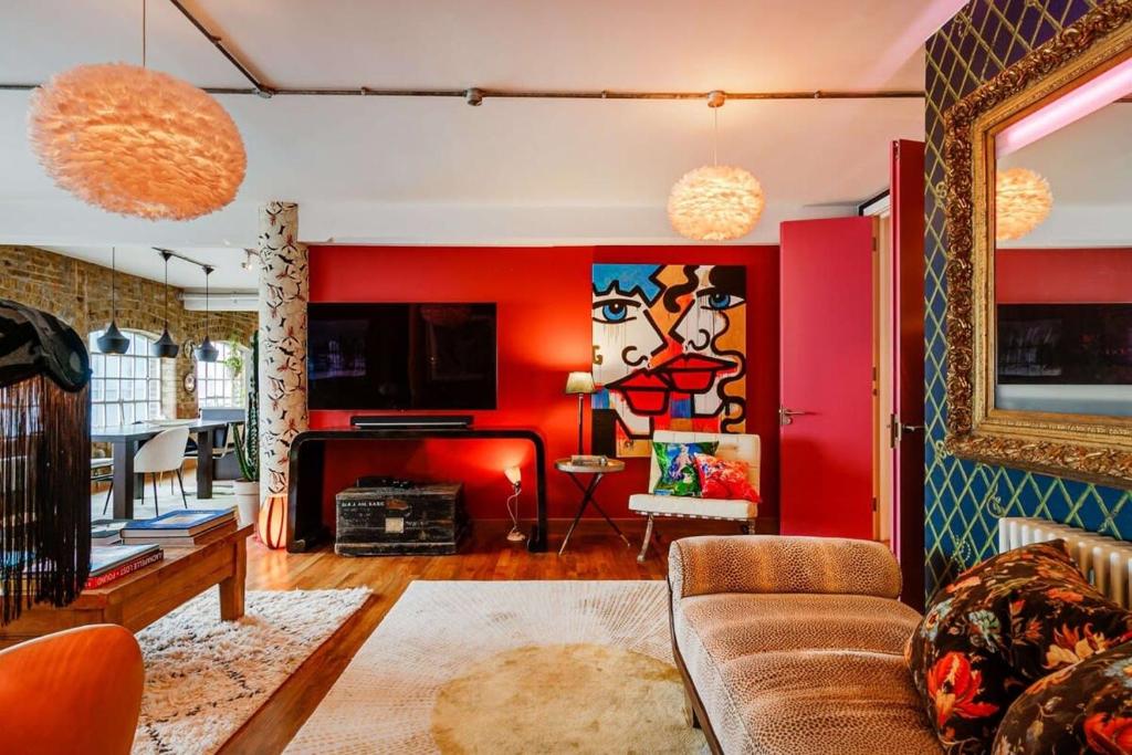 a living room with red walls and a couch at Luxury Bermondsey Warehouse Loft with Lift in London
