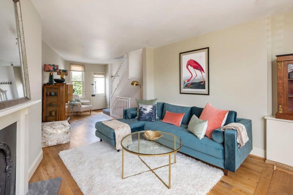 a living room with a blue couch and a glass table at Divine Georgian Townhouse in the heart of Bath in Bath