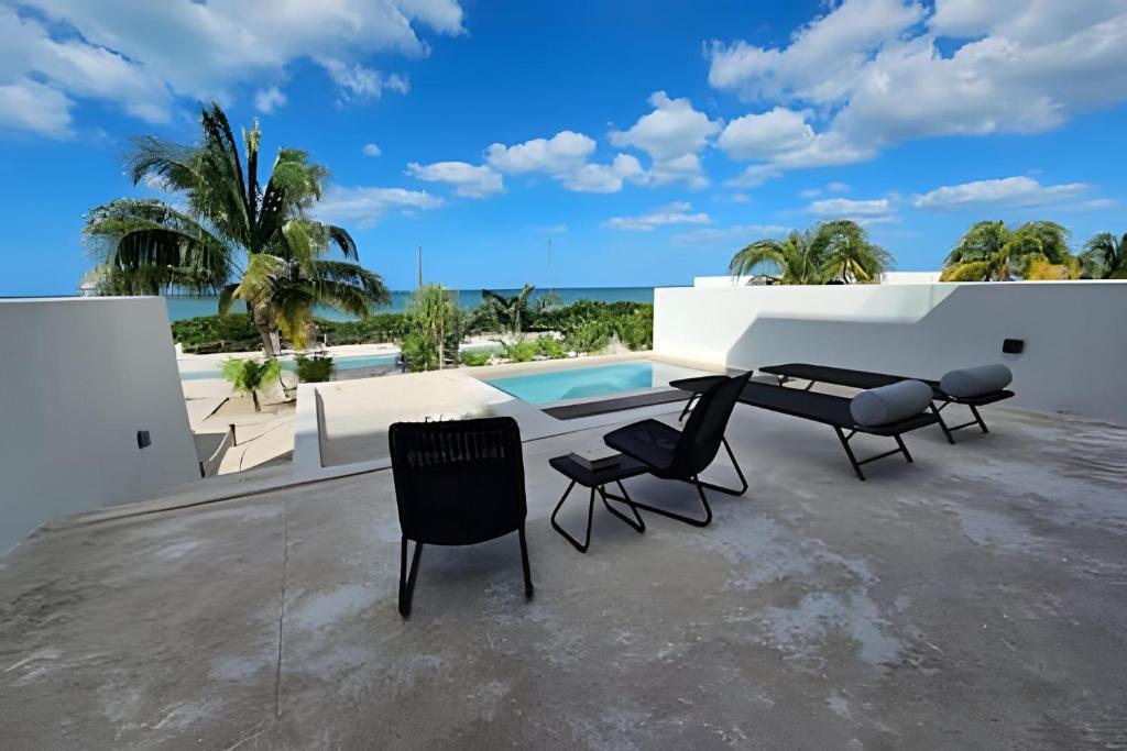 un patio con 2 sedie, un tavolo e una piscina di Turena depto. frente a la playa a Telchac Puerto